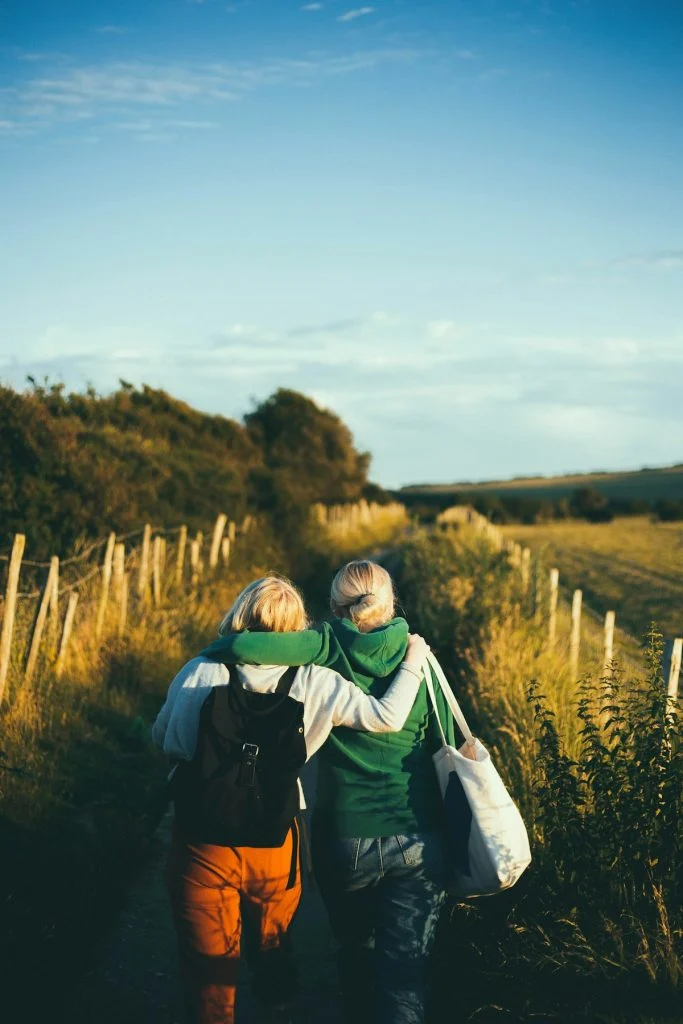 Two people supporting one another on a walk